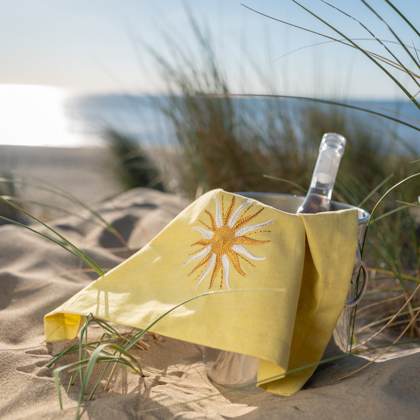 Botergeel servet met zonneborduursel in wijnkoeler