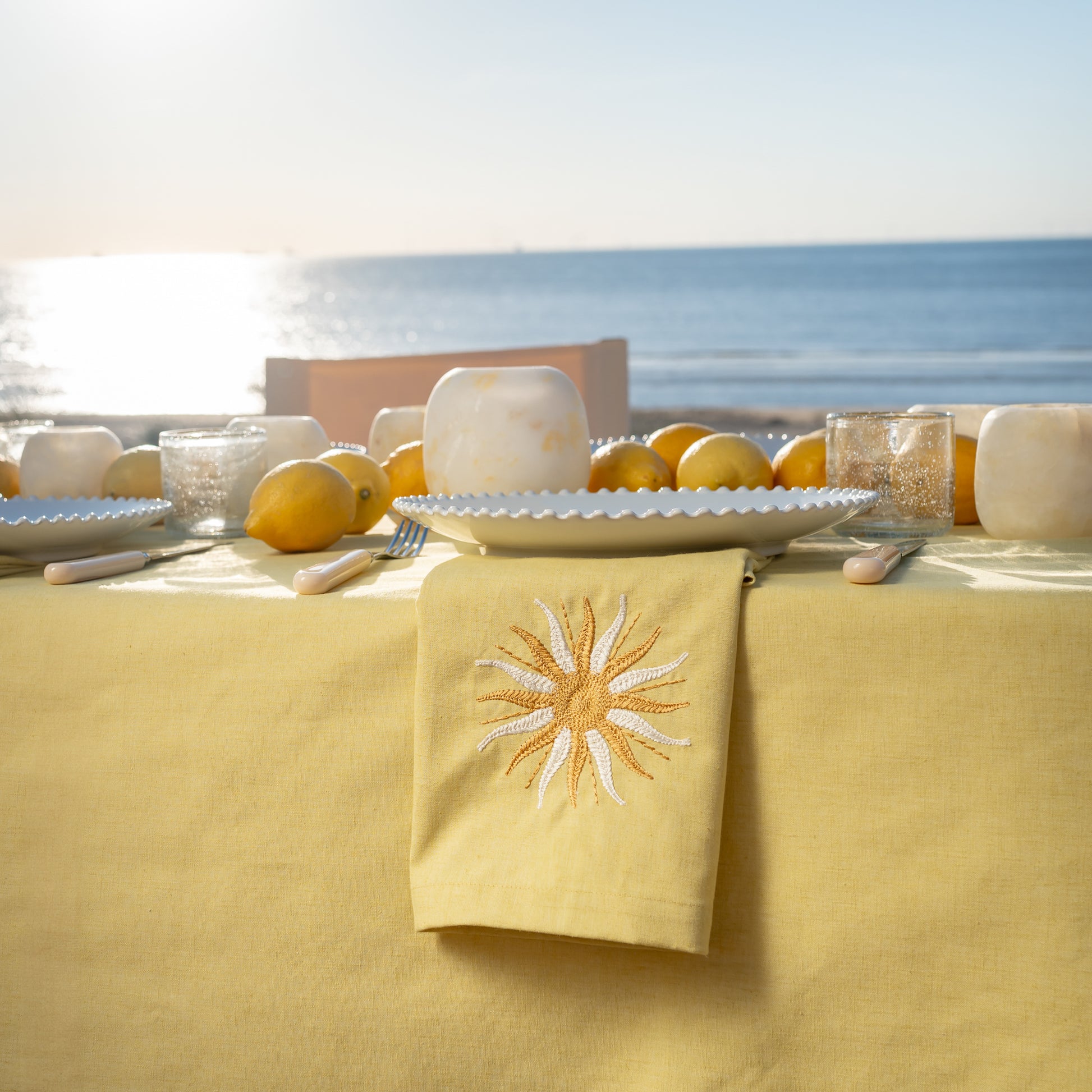 Botergeel tafelkleel servet met zon borduursel en alabaster waxinelicht