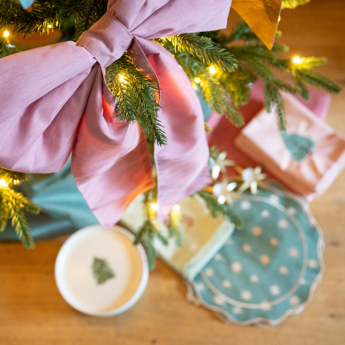 Roze kerststrik in kerstboom met kerstcadeautjes