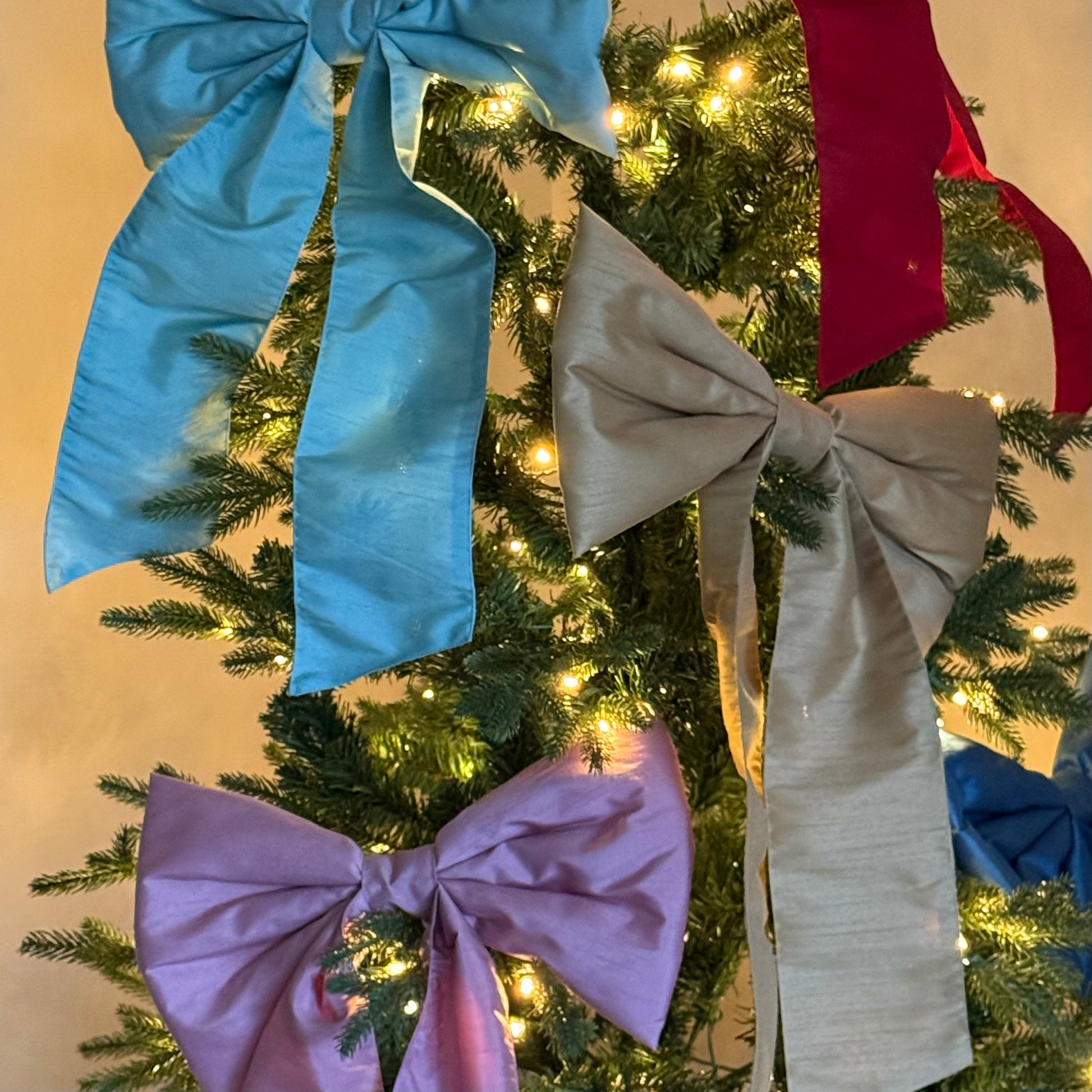 Kerstboom versierd met verschillende grote strikken van stof