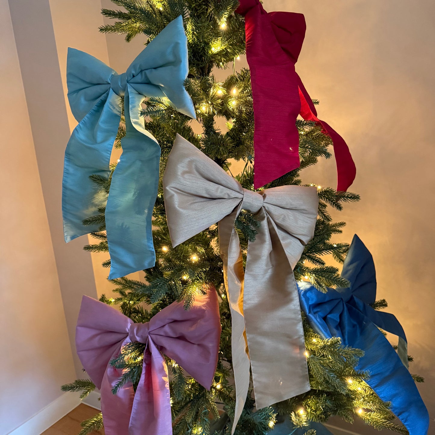 Kerstboom versierd met verschillende kleuren strikken van stof