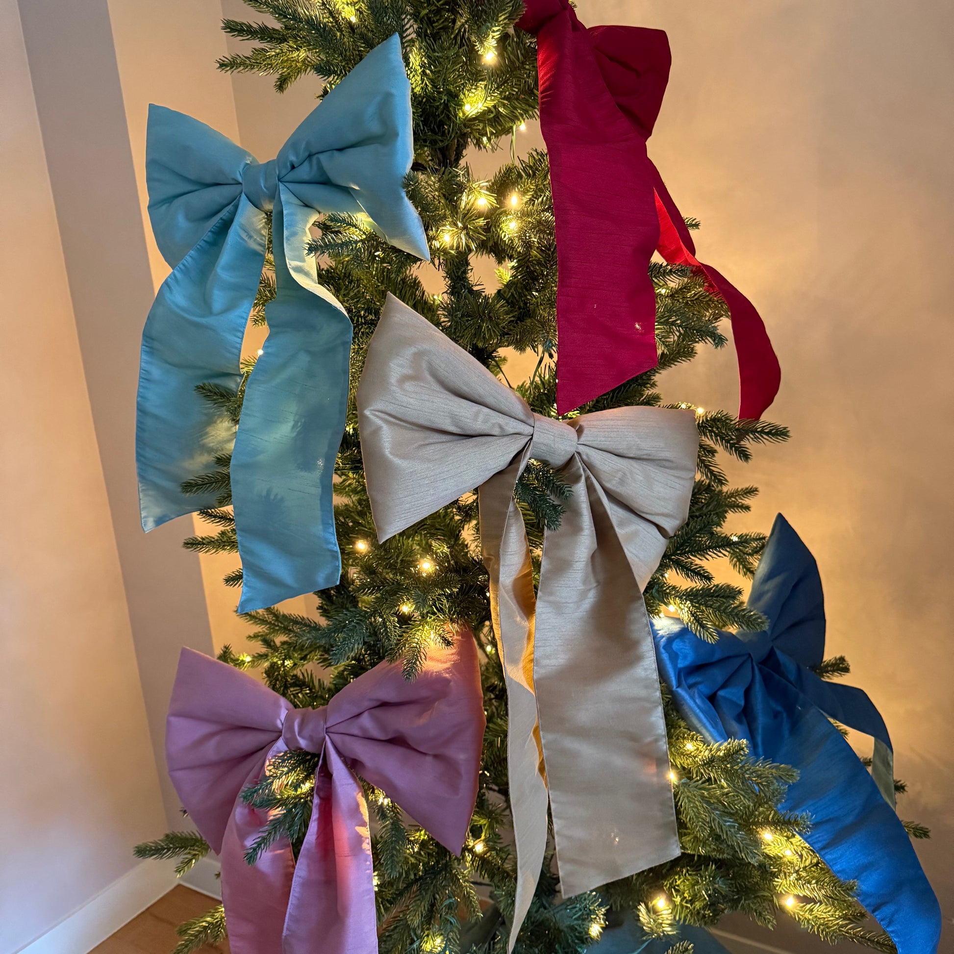 Kerstboom versierd met verschillende kleuren strikken van stof